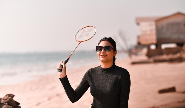 jong gelukkig meisje tennissen op strand Indiase Pakistaanse model