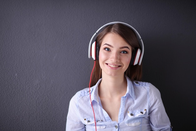 Jong gelukkig meisje zittend op de vloer en muziek luisteren