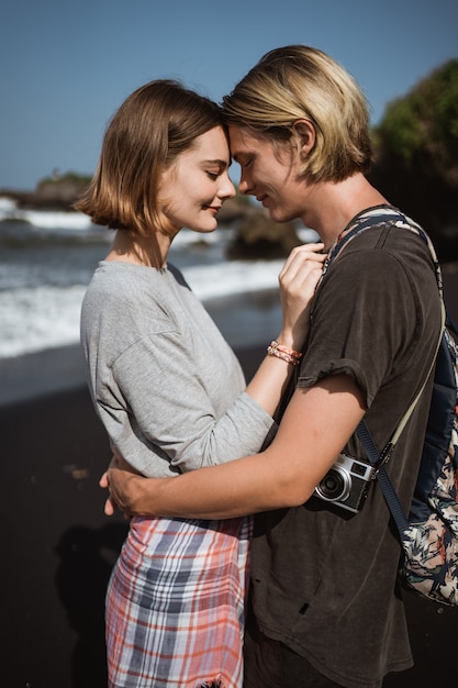 Jong gelukkig paar dat pret op het strand heeft