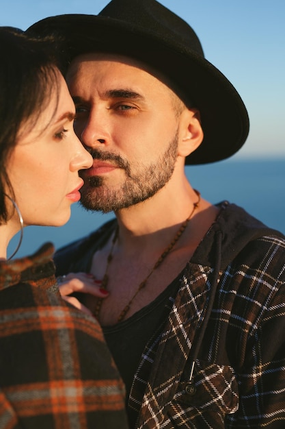 Jong gelukkig paar verliefd op een romantisch moment wanneer een man een vrouw kust met uitzicht op zee