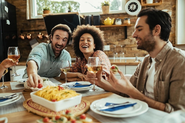 Jong gelukkig stel dat plezier heeft tijdens de lunch met hun vrienden thuis