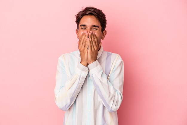 Jong gemengd ras man geïsoleerd op een witte achtergrond lachen om iets, die mond met handen bedekken.