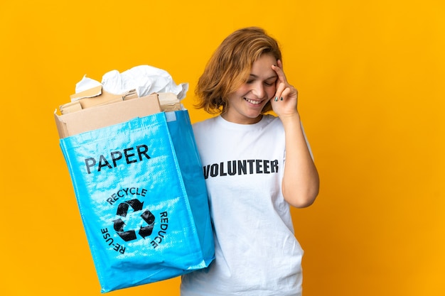 Jong Georgisch meisje dat een recyclingzak vol met papier houdt om te lachen