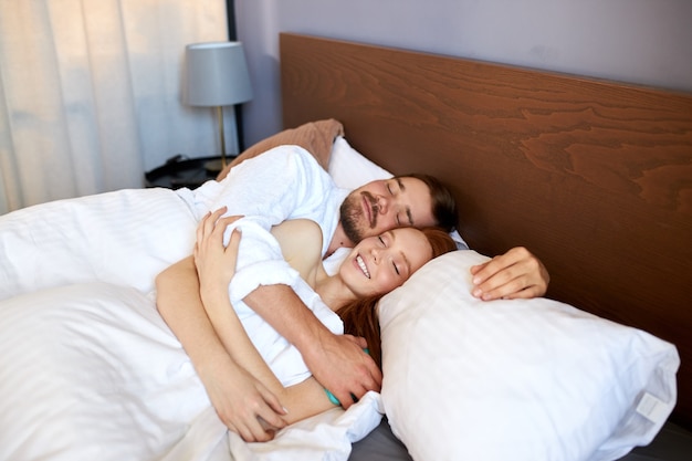 Jong getrouwd stel slapen samen, liggen 's ochtends op bed