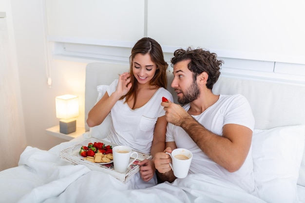 Jong getrouwd stel verliefd ontbijten in hun bed Goedemorgen Gezond ontbijt op bed Jong mooi liefdespaar ontbijt op bed