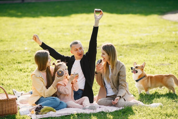 Jong gezin en hun corgi-hond picknicken in een park