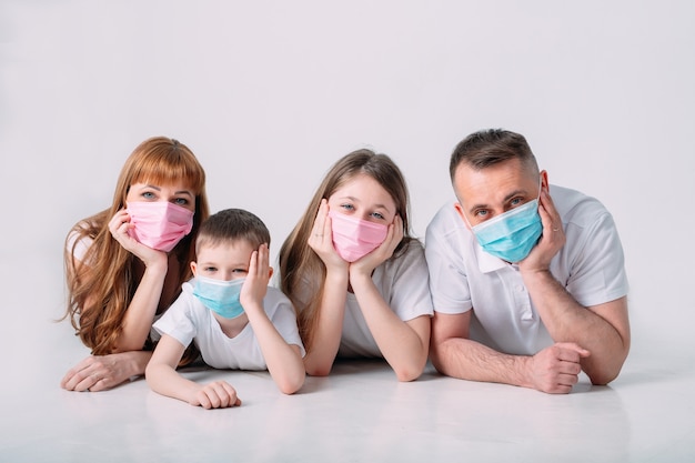 Jong gezin in medische maskers tijdens quarantaine thuis.