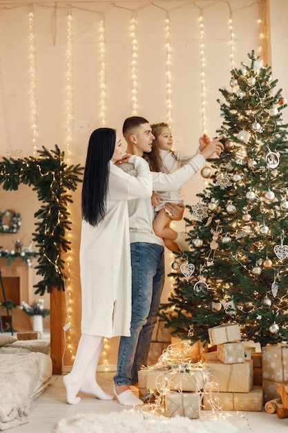 Jong gezin kerstboom versieren en samen vieren