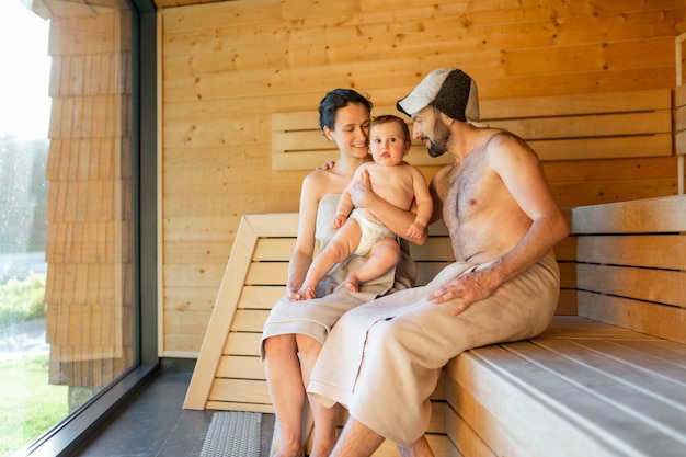 Jong gezin met een kleine jongen in sauna