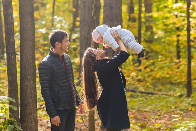 Jong gezin met hun pasgeboren baby tijd buiten doorbrengen in het herfstpark.