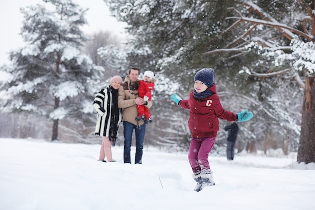 Jong gezin met kinderen wandelen in het winterpark. Winterwandeling van ouders met kinderen. Wandelen op vakantieweekend in de winter.