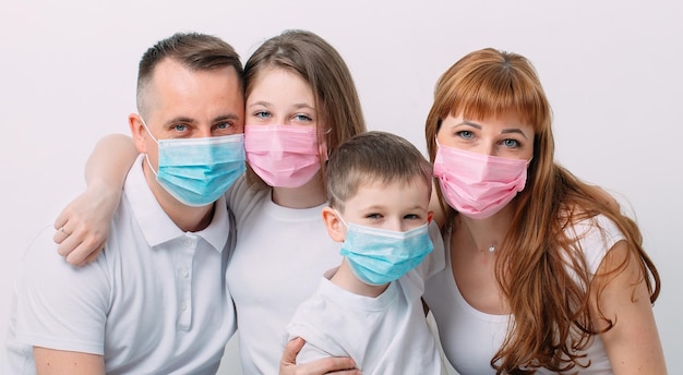 Jong gezin met medische maskers tijdens thuisquarantaine.