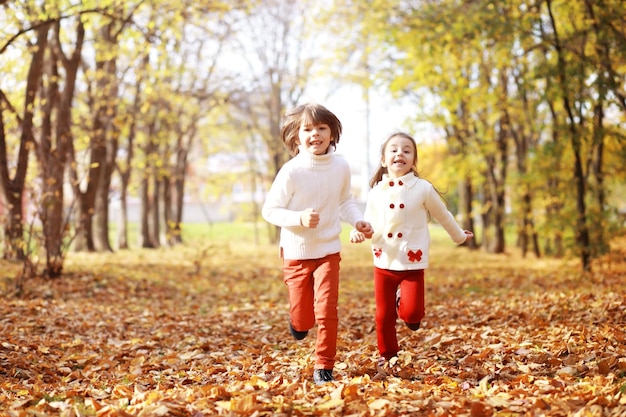 Jong gezin op een wandeling in het herfstpark op een zonnige dag Geluk om samen te zijn