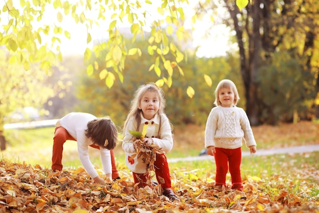 Jong gezin op een wandeling in het herfstpark op een zonnige dag Geluk om samen te zijn