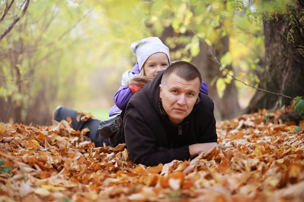 Jong gezin op een wandeling in het herfstpark op een zonnige dag Geluk om samen te zijn