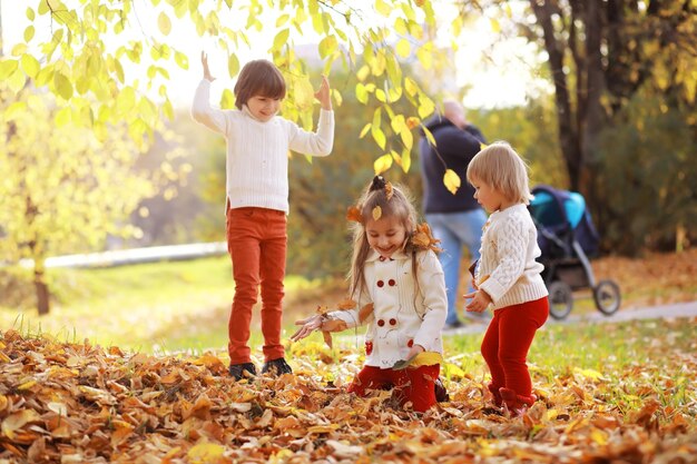 Jong gezin op een wandeling in het herfstpark op een zonnige dag Geluk om samen te zijn