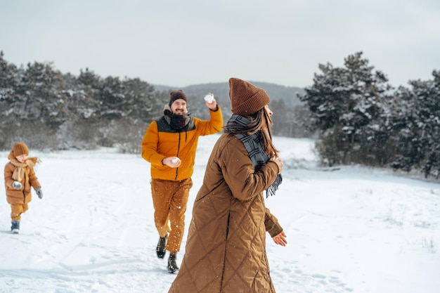 Jong gezin plezier in besneeuwde winterbos