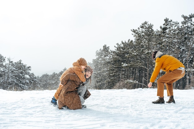 Jong gezin plezier in besneeuwde winterbos