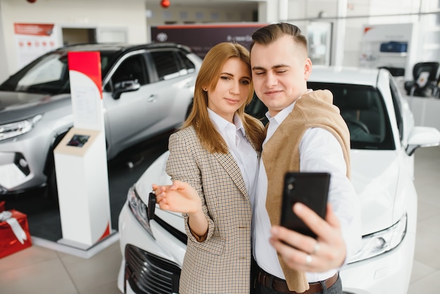 Jong gezin selfie maken in een auto-showroom