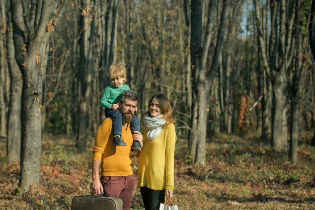 Jong gezin van moeder, vader en zoon wandelen in het bos op vakantie. Klein kind en ouders op vakantie. Samen genieten