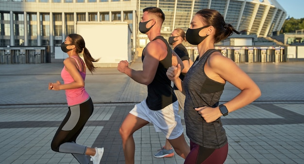 Jong hardloopteam met meerdere races in training met beschermende maskers