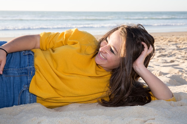 Jong hipstermeisje op het strand met het overzees op de achtergrond
