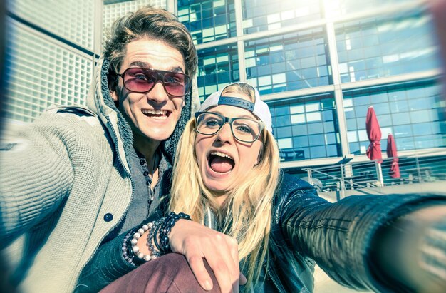 Jong hipsterpaar dat verliefd is op het nemen van een grappige selfie op de achtergrond van de stedelijke stad