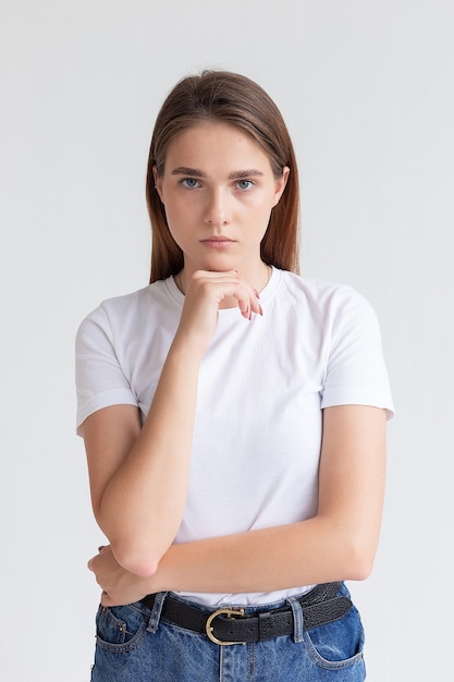 Jong Kaukasisch mooi meisje met lang haar in t-shirt, spijkerbroek bij studio