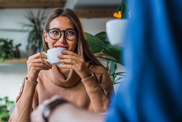 Foto jong kaukasisch paar dat koffie drinkt in een coffeeshop