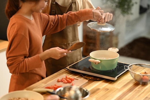 Jong koppel bereidt samen een heerlijke maaltijd voor in de keuken Mensen voedsel en levensstijl concept