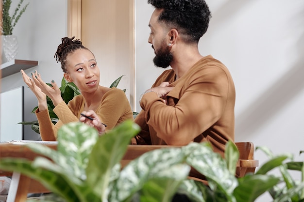 Jong koppel bespreken gezinsbudget wanneer ze thuis aan tafel zitten