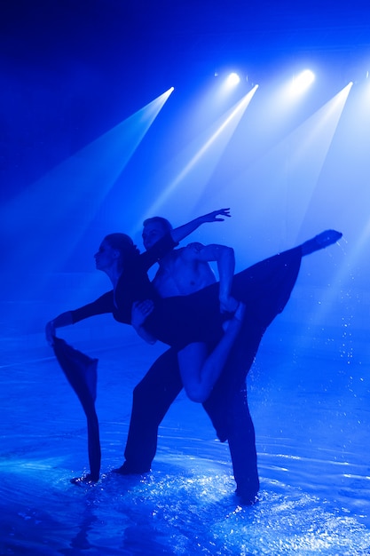 Jong koppel dansen in het water.