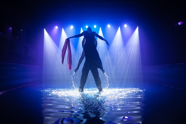 Jong koppel dansen in het water.