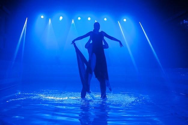 Jong koppel dansen in het water.