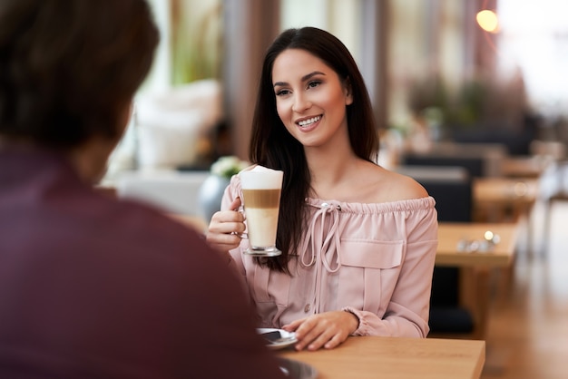 jong koppel genieten van koffie en cake in café