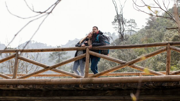 Foto jong koppel in de natuur zittend op de brug