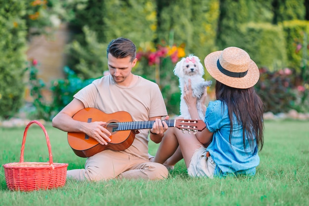 Jong koppel in het park gitaar spelen