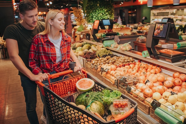 Jong koppel in supermarkt duwen grafiek