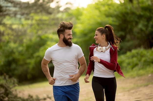 Jong koppel joggen buiten in de natuur