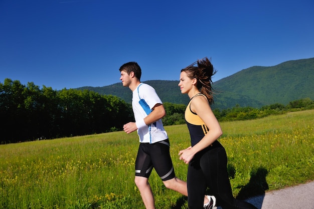 Jong koppel joggen in het park in de ochtend. Gezondheid en fitness.