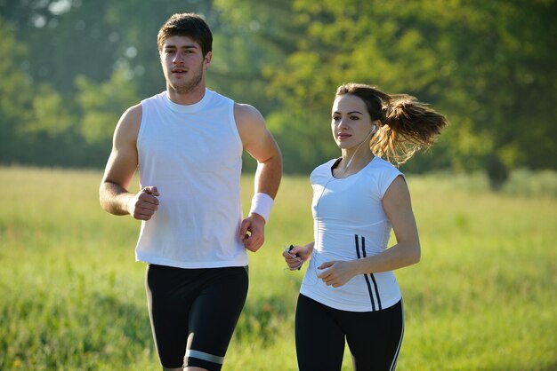 Jong koppel joggen in het park in de ochtend. Gezondheids- en fitnessconcept