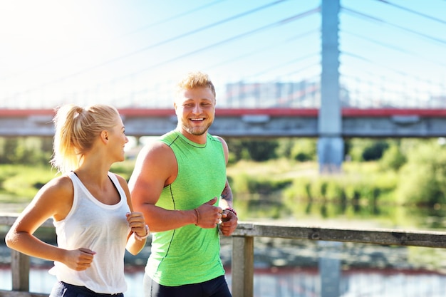 Jong koppel joggen in het park in de zomer