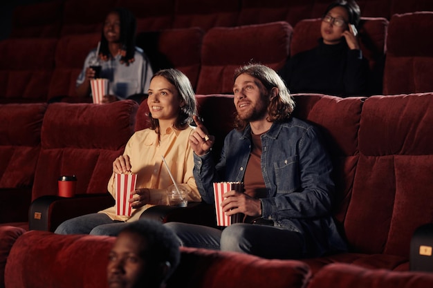 Jong koppel kijken naar film in de bioscoop