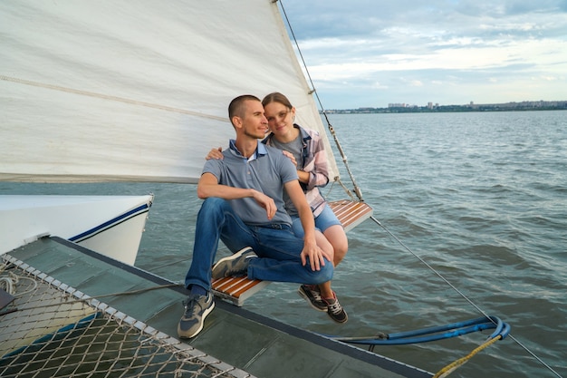 Jong koppel knuffelen, zittend op de boot genietend van zomerdag