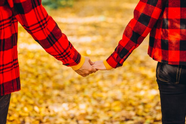 Jong koppel loopt hand in hand door het herfstbos