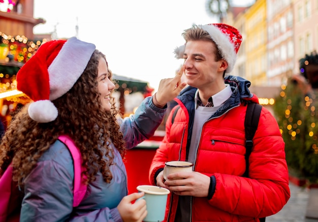 Jong koppel met drankjes op kerstmarkt in Wroclaw, Polen