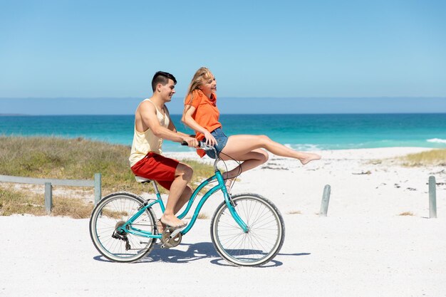 Jong koppel met fiets op het strand