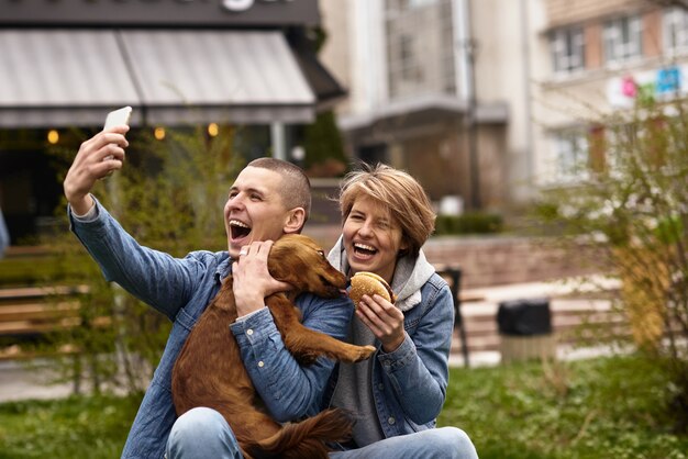 Jong koppel met hond met fast-food lunch