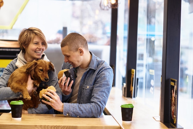 Foto jong koppel met hond met fastfood lunch