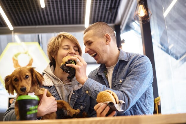 Foto jong koppel met hond met fastfood lunch